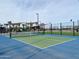 Community pickleball court with blue and green surface surrounded by playground and landscaping at 22701 E Saddle Way, Queen Creek, AZ 85142