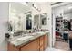 Bathroom featuring double vanity, granite countertops, and convenient access to a walk-in closet at 24207 W Desert Bloom St, Buckeye, AZ 85326