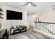 Hallway view features a TV on the wall, neutral walls, and an open landing creating a welcoming space at 24207 W Desert Bloom St, Buckeye, AZ 85326