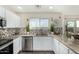 Well-lit kitchen with white cabinets, granite countertops, stainless steel appliances, and modern backsplash at 24207 W Desert Bloom St, Buckeye, AZ 85326