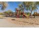 Community playground features a slide, a shaded pavilion, and mature trees creating a recreational outdoor space at 24207 W Desert Bloom St, Buckeye, AZ 85326