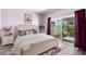 Cozy bedroom with light purple walls, stylish bedding, bedside table and direct access to the outdoors at 2714 W Desert Cove Ave, Phoenix, AZ 85029
