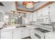 Contemporary kitchen with white cabinetry, countertops, a convenient breakfast bar, and modern lighting at 2714 W Desert Cove Ave, Phoenix, AZ 85029