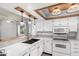 Well-lit kitchen features white cabinets, white countertops, modern appliances, and decorative hanging lights at 2714 W Desert Cove Ave, Phoenix, AZ 85029