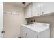Practical laundry room featuring modern washer and dryer with ample storage cabinets at 2714 W Desert Cove Ave, Phoenix, AZ 85029