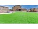 Lush backyard with a pool, play area, and covered patio creates an ideal space for outdoor relaxation and entertainment at 284 N 199Th Dr, Buckeye, AZ 85326
