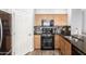 Galley kitchen featuring stainless appliances, granite countertops, wood cabinets, and black backsplash at 284 N 199Th Dr, Buckeye, AZ 85326