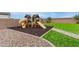Backyard playground offers outdoor fun on artificial turf, complete with a slide, swing set, and wooden playhouse at 284 N 199Th Dr, Buckeye, AZ 85326