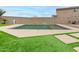 Backyard pool with a charming water feature, surrounded by green turf and stylish stone pavers, offers a serene retreat at 284 N 199Th Dr, Buckeye, AZ 85326