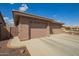 Garage exterior showing 3 car garage with stone accents and neutral desert landscaping at 2842 S Royal Wood --, Mesa, AZ 85212