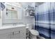 Clean bathroom with a white vanity, toilet, and shower featuring a blue patterned curtain at 306 N Winthrop Cir, Mesa, AZ 85213