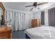 Comfortable bedroom with a ceiling fan, floral patterned curtains, and two dressers at 306 N Winthrop Cir, Mesa, AZ 85213