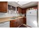 Functional kitchen featuring a double sink, wooden cabinets, and good natural lighting from a window at 306 N Winthrop Cir, Mesa, AZ 85213