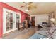 A vintage living room featuring a red wall, French doors, and a cozy seating area at 306 N Winthrop Cir, Mesa, AZ 85213