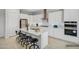 Bright kitchen with stainless steel appliances, white cabinets, an island, and barstool seating at 32297 N 133Rd Ln, Peoria, AZ 85383