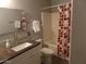 Cozy bathroom featuring a vanity with granite countertops, a shower with red patterned curtains, and modern fixtures at 39837 N Manetti St, San Tan Valley, AZ 85140