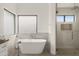 Bright bathroom featuring a sleek soaking tub and glass-enclosed shower with a rainfall showerhead at 40198 N 105Th Pl, Scottsdale, AZ 85262
