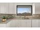 Bright kitchen with stainless steel sink, white cabinets and marble countertops and backsplash at 40198 N 105Th Pl, Scottsdale, AZ 85262