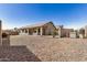Backyard with desert landscaping and a covered patio adjacent to the house at 41848 W Michaels Dr, Maricopa, AZ 85138