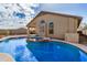 Backyard swimming pool and hot tub surrounded by a block fence and desert landscaping at 41848 W Michaels Dr, Maricopa, AZ 85138
