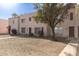 Well-maintained townhome exterior with desert landscaping, mature tree and shutters at 4625 W Thomas Rd # 19, Phoenix, AZ 85031