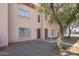 Charming townhouse exterior with tidy landscaping and a shade tree near the entrance at 4625 W Thomas Rd # 19, Phoenix, AZ 85031