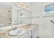 Bright bathroom with double sinks, large mirror, updated lighting, and walk-in shower at 4743 W Laurel Ln, Glendale, AZ 85304