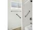 Accessible walk-in shower with safety bars and adjustable shower head, tiled walls and window at 4743 W Laurel Ln, Glendale, AZ 85304