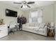 A cozy bedroom features a white couch, desk, TV, and a ceiling fan for a comfortable and functional space at 5016 N 68Th Dr, Glendale, AZ 85303
