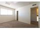 Neutral carpeted bedroom with large window letting in natural light and double closet at 5133 W Hearn Rd, Glendale, AZ 85306