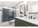 Modern bathroom features marble walls, double sink vanity, and walk-in shower with blue subway tile at 5561 W Greenbriar Dr, Glendale, AZ 85308