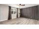 Bright bedroom with a feature wall, neutral paint, wood-style tile floors, and a ceiling fan at 5561 W Greenbriar Dr, Glendale, AZ 85308