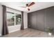 Stylish bedroom features a modern ceiling fan, wainscotting, and a large window offering natural light at 5561 W Greenbriar Dr, Glendale, AZ 85308