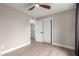 Bright bedroom with light hardwood floors, a ceiling fan, and a view of the hallway through a doorway at 5561 W Greenbriar Dr, Glendale, AZ 85308