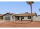 Charming single-story home with an attached two-car garage, neutral color palette, and mature palm trees at 5561 W Greenbriar Dr, Glendale, AZ 85308