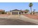 Charming single-story home with a spacious driveway, mature palm trees, and desert-friendly landscaping at 5561 W Greenbriar Dr, Glendale, AZ 85308
