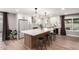 Beautiful kitchen featuring white cabinets, geometric pendant lighting, stainless appliances, and a large island at 5561 W Greenbriar Dr, Glendale, AZ 85308