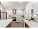 Close-up of a modern kitchen with white cabinets, chevron backsplash, stainless appliances and counter seating at 5561 W Greenbriar Dr, Glendale, AZ 85308