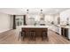 Stylish kitchen with white cabinets, herringbone backsplash, stainless appliances, pendant lighting, and island seating at 5561 W Greenbriar Dr, Glendale, AZ 85308