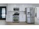Modern kitchen with stainless steel appliances, double oven, white cabinets, and quartz countertops for a clean and bright space at 623 N Parsell --, Mesa, AZ 85203