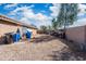 A spacious backyard with block fence is ready for your personalization. Utility bins and building materials are present at 6922 S 26Th Ln, Phoenix, AZ 85041