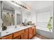 Bright bathroom boasts a dual sink vanity, soaking tub, and a separate glass enclosed shower at 6922 S 26Th Ln, Phoenix, AZ 85041
