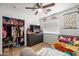 Bright bedroom features a ceiling fan, tiled floors, dresser, and an organized closet providing ample storage space at 6922 S 26Th Ln, Phoenix, AZ 85041