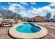 Backyard pool is surrounded by gravel and a block wall fence, with a covered sitting area in the distance at 6922 S 26Th Ln, Phoenix, AZ 85041