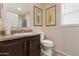 Cozy bathroom with a vanity, toilet, framed prints, and neutral-toned walls at 7807 E Main St # Cc-98, Mesa, AZ 85207