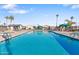 Large swimming pool with palm trees and lounge chairs, offering a resort-style experience for residents at 7807 E Main St # Cc-98, Mesa, AZ 85207