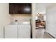 Functional laundry area with washer, dryer, storage cabinets, and entry to the living room at 7807 E Main St # Cc-98, Mesa, AZ 85207