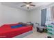 Bedroom with ceiling fan, neutral walls, and a window providing natural light at 8339 W Devonshire Ave, Phoenix, AZ 85037