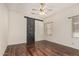 Spacious bedroom featuring vinyl wood floors, bright light, and a barn door at 9644 N 97Th Ln, Peoria, AZ 85345