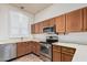 Bright kitchen with wood cabinets, stainless steel appliances, and a window with shutter blinds at 9644 N 97Th Ln, Peoria, AZ 85345